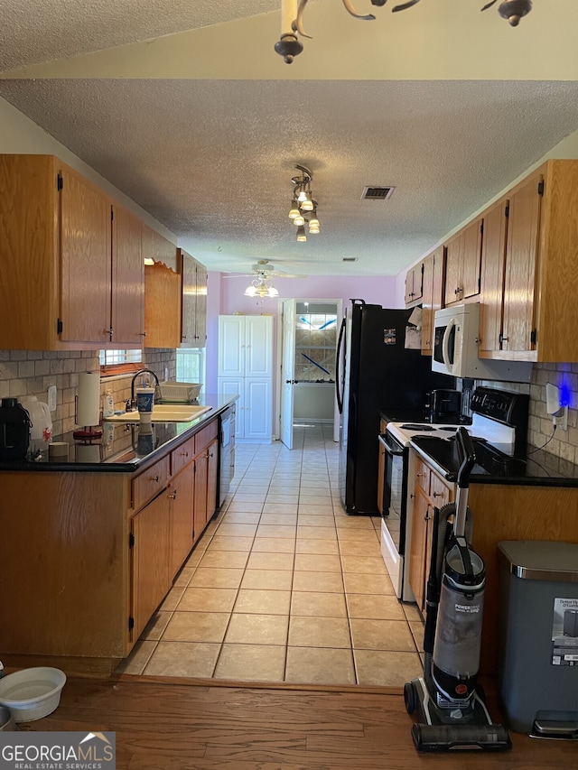 102 Driftwood Ct, Kingsland, GA 31548 - kitchen with white appliances, dark countertops, a sink, backsplash, and a textured ceiling