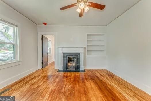 2 E 10th St SW, Rome, GA 30161 - unfurnished living room with built in shelves, ceiling fan, a fireplace with flush hearth, wood finished floors, and baseboards