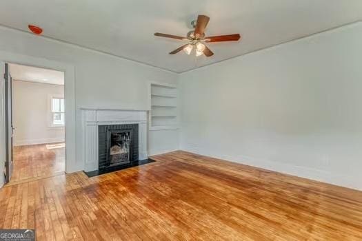 2 E 10th St SW, Rome, GA 30161 - unfurnished living room featuring ceiling fan, built in features, wood-type flooring, a fireplace with flush hearth, and baseboards