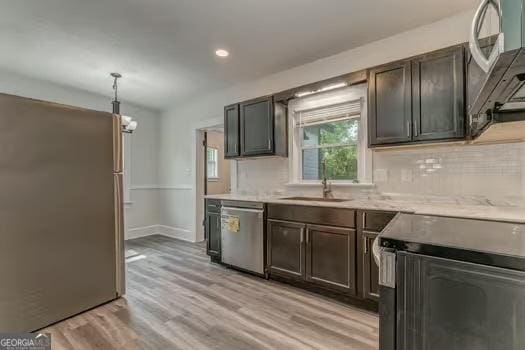 2 E 10th St SW, Rome, GA 30161 - kitchen with appliances with stainless steel finishes, light wood finished floors, a sink, tasteful backsplash, and light countertops