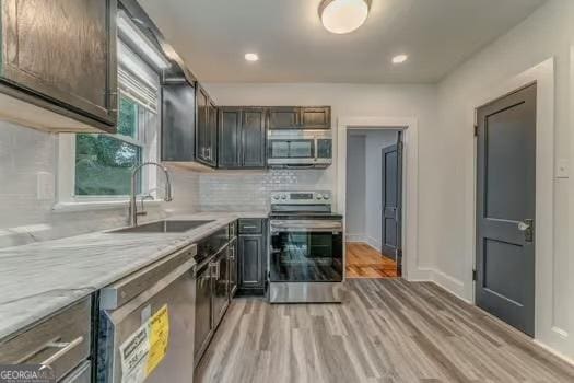 2 E 10th St SW, Rome, GA 30161 - kitchen featuring stainless steel appliances, a sink, light countertops, backsplash, and light wood-style floors