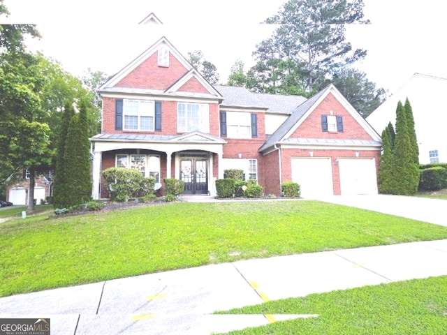 779 Avonley Creek Trce, Buford, GA 30518 - view of front facade with french doors, driveway, brick siding, and a front lawn