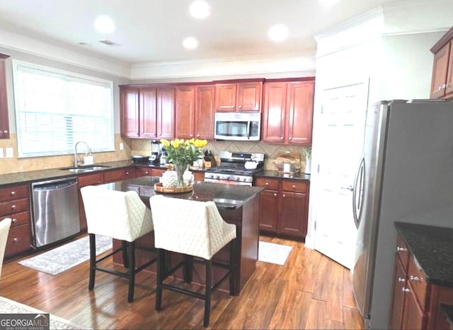 779 Avonley Creek Trce, Buford, GA 30518 - kitchen featuring appliances with stainless steel finishes, wood finished floors, ornamental molding, decorative backsplash, and reddish brown cabinets