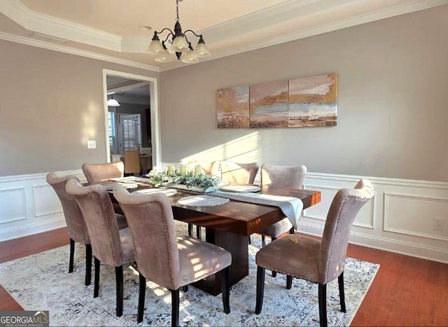 779 Avonley Creek Trce, Buford, GA 30518 - dining room featuring a chandelier, wood finished floors, a decorative wall, ornamental molding, and a wainscoted wall