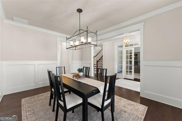 3317 Sweetleaf Ln, Buford, GA 30519 - dining space with a chandelier, ornamental molding, wainscoting, stairs, and dark wood finished floors