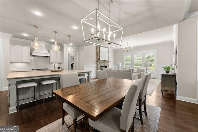 3317 Sweetleaf Ln, Buford, GA 30519 - dining space featuring a chandelier, recessed lighting, crown molding, dark wood-style floors, and wainscoting