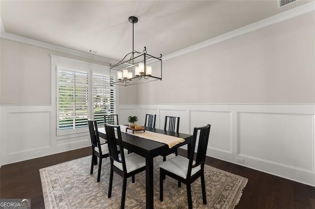 3317 Sweetleaf Ln, Buford, GA 30519 - dining room with a chandelier, a wainscoted wall, a decorative wall, ornamental molding, and dark wood-style floors
