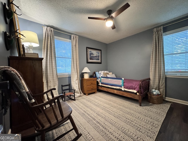 353 Lewis Cir, Commerce, GA 30529 - bedroom featuring a textured ceiling, multiple windows, wood finished floors, a ceiling fan, and baseboards