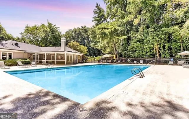 2119 Pine Heights Dr NE, Atlanta, GA 30324 - pool at dusk with a patio, a community pool, and view of scattered trees
