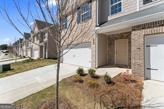 2861 Fareed Unit 40, Douglasville, GA 30135 - view of side of property featuring an attached garage, concrete driveway, brick siding, and roof with shingles