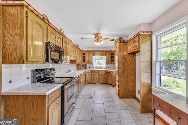 4911 Old Douglasville Rd, Lithia Springs, GA 30122 - kitchen with stainless steel electric stove, black microwave, a sink, backsplash, and a ceiling fan