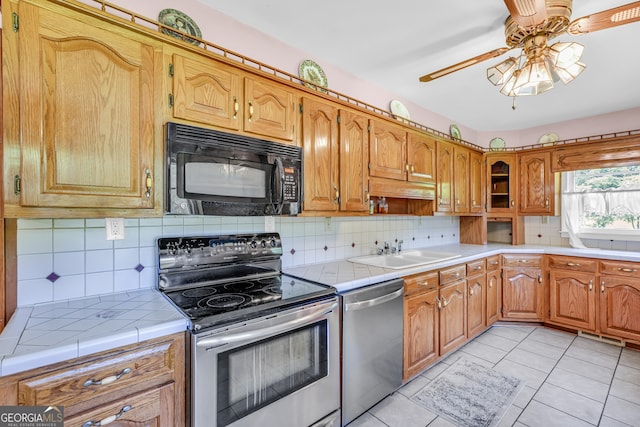 4911 Old Douglasville Rd, Lithia Springs, GA 30122 - kitchen with stainless steel appliances, tile countertops, ceiling fan, and a sink