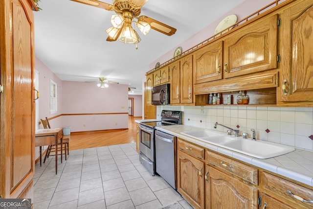 4911 Old Douglasville Rd, Lithia Springs, GA 30122 - kitchen with a ceiling fan, appliances with stainless steel finishes, tile counters, and a sink