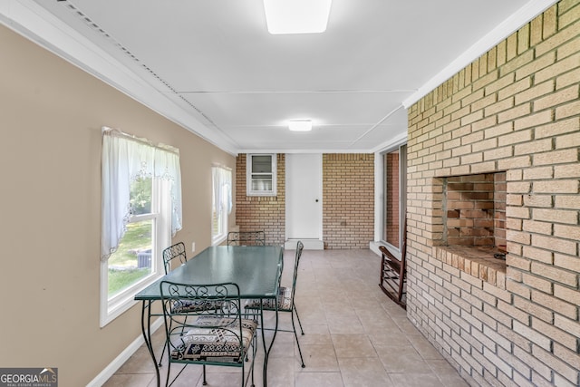 4911 Old Douglasville Rd, Lithia Springs, GA 30122 - dining space featuring brick wall, light tile patterned floors, and crown molding