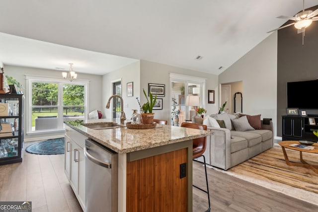 102 Bowline Ln, Kingsland, GA 31548 - kitchen with stainless steel dishwasher, a sink, light wood-type flooring, a center island with sink, and a kitchen breakfast bar