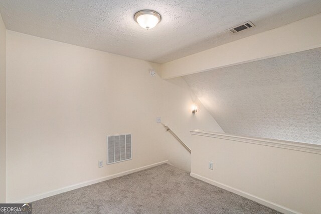 855 Lakeside Cir, Covington, GA 30016 - carpeted spare room with vaulted ceiling, a textured ceiling, and baseboards