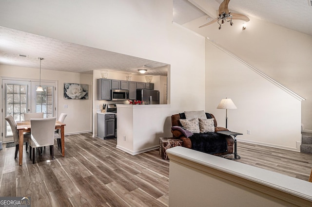 855 Lakeside Cir, Covington, GA 30016 - living room featuring a textured ceiling, dark wood-style flooring, a ceiling fan, baseboards, and high vaulted ceiling