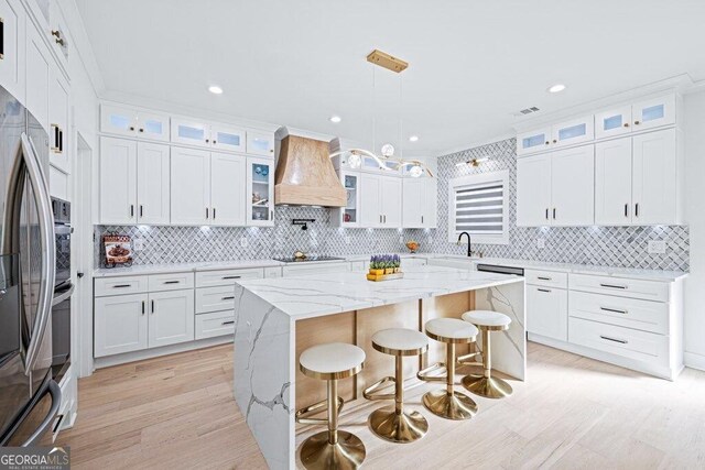 29 Cedar Blf, Winder, GA 30680 - kitchen with premium range hood, light wood-style flooring, black electric stovetop, backsplash, and recessed lighting