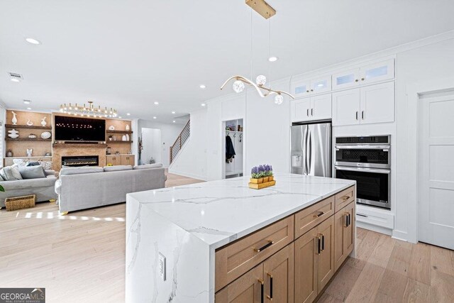29 Cedar Blf, Winder, GA 30680 - kitchen featuring stainless steel appliances, light wood-style floors, a center island, white cabinetry, and hanging light fixtures