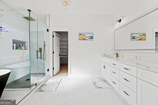 29 Cedar Blf, Winder, GA 30680 - full bath with a marble finish shower, marble finish flooring, a freestanding bath, vanity, and a chandelier