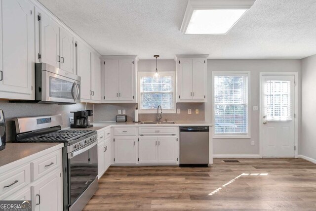 239 Taylors Farm Dr, Canton, GA 30115 - kitchen with appliances with stainless steel finishes, a sink, light wood-style flooring, white cabinets, and a textured ceiling
