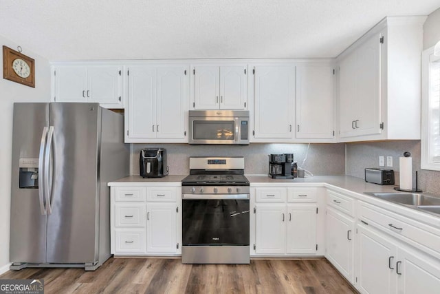 239 Taylors Farm Dr, Canton, GA 30115 - kitchen with stainless steel appliances, white cabinets, wood finished floors, and light countertops