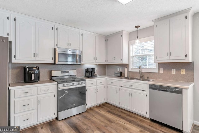 239 Taylors Farm Dr, Canton, GA 30115 - kitchen with appliances with stainless steel finishes, a sink, white cabinetry, wood finished floors, and a textured ceiling