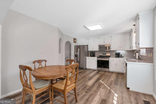 239 Taylors Farm Dr, Canton, GA 30115 - kitchen featuring stainless steel appliances, a sink, wood finished floors, white cabinets, and light countertops
