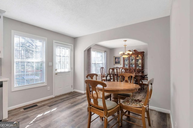 239 Taylors Farm Dr, Canton, GA 30115 - dining area featuring arched walkways, wood finished floors, baseboards, a chandelier, and a textured ceiling