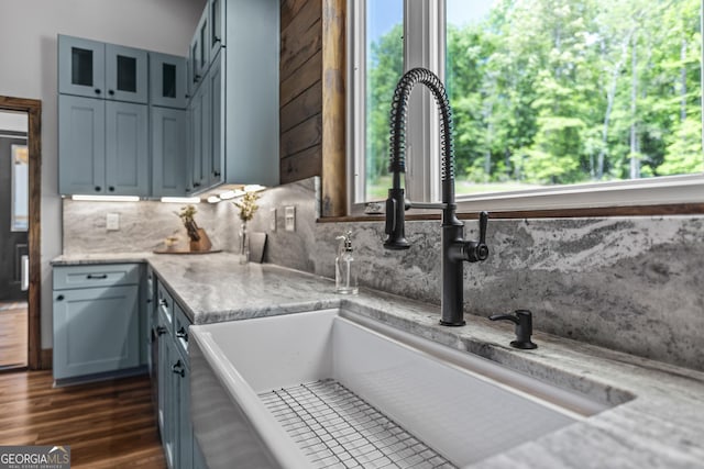 795 E Jones Chapel Rd, Danielsville, GA 30633 - kitchen featuring backsplash, glass insert cabinets, light stone countertops, and dark wood-style floors