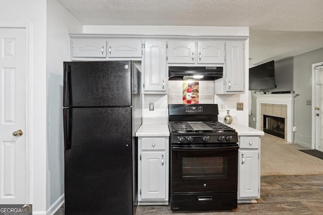 11529 Vinea Ln, Hampton, GA 30228 - kitchen featuring black appliances, under cabinet range hood, light countertops, dark wood-type flooring, and a textured ceiling
