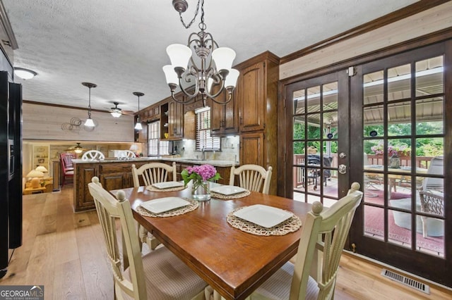 4205 Jeri Lynn Ct, Tucker, GA 30084 - dining room featuring wood walls, light wood-type flooring, a textured ceiling, ceiling fan, and a chandelier