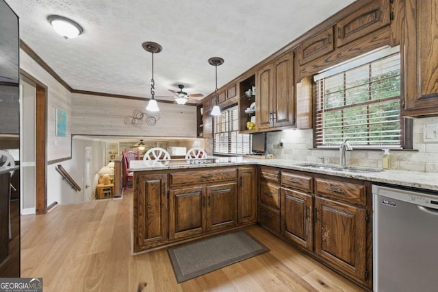 4205 Jeri Lynn Ct, Tucker, GA 30084 - kitchen with stainless steel dishwasher, a sink, a peninsula, a textured ceiling, and light wood-style floors