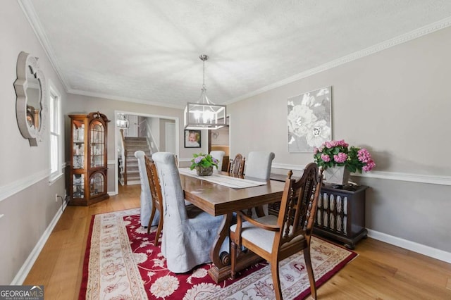 4205 Jeri Lynn Ct, Tucker, GA 30084 - dining room with a chandelier, light wood finished floors, stairs, baseboards, and crown molding
