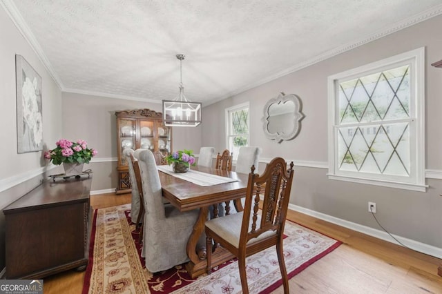 4205 Jeri Lynn Ct, Tucker, GA 30084 - dining room featuring a chandelier, light wood-style flooring, a textured ceiling, baseboards, and ornamental molding