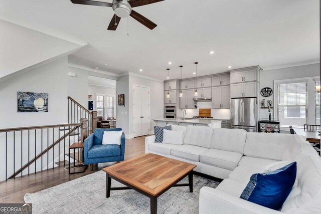 3108 Huntington Pl, Milton, GA 30004 - living room with a ceiling fan, plenty of natural light, light wood-style flooring, recessed lighting, and ornamental molding