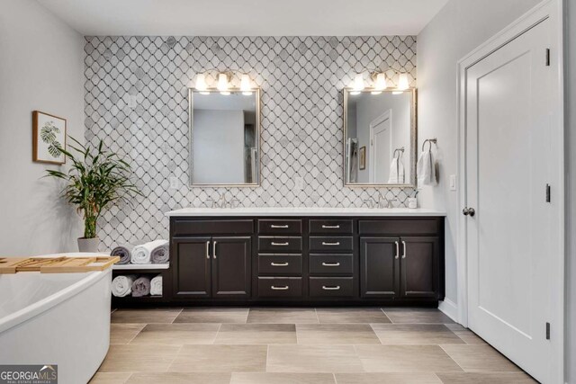 3108 Huntington Pl, Milton, GA 30004 - bathroom with double vanity, a freestanding bath, and an accent wall