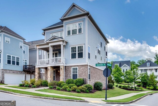 3108 Huntington Pl, Milton, GA 30004 - view of property with brick siding, a front yard, a ceiling fan, an attached garage, and a balcony