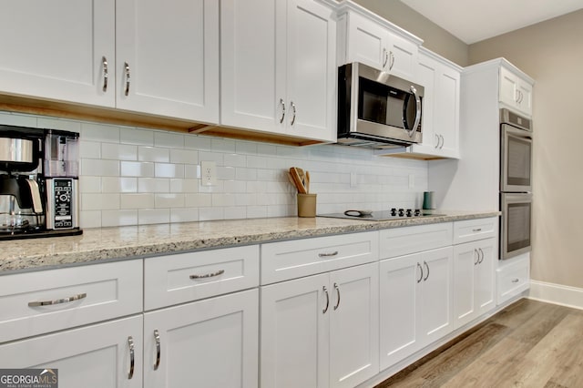 234 Thyme Leaf Way, Locust Grove, GA 30248 - kitchen featuring appliances with stainless steel finishes, light wood finished floors, white cabinetry, tasteful backsplash, and baseboards