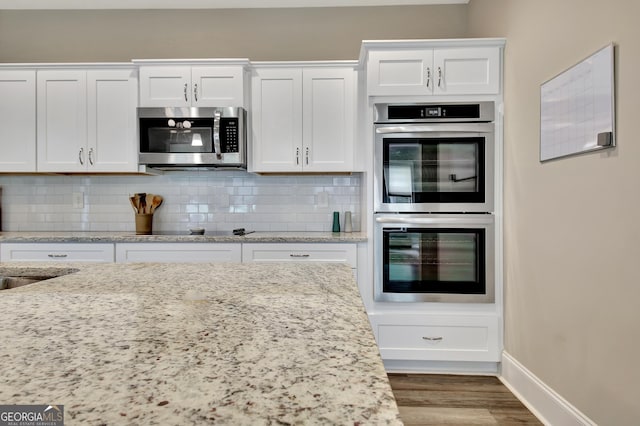 234 Thyme Leaf Way, Locust Grove, GA 30248 - kitchen featuring appliances with stainless steel finishes, white cabinets, backsplash, and wood finished floors