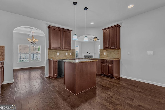 4238 Sir Dixon Dr, Fairburn, GA 30213 - kitchen featuring arched walkways, dark wood-type flooring, tasteful backsplash, a chandelier, and hanging light fixtures