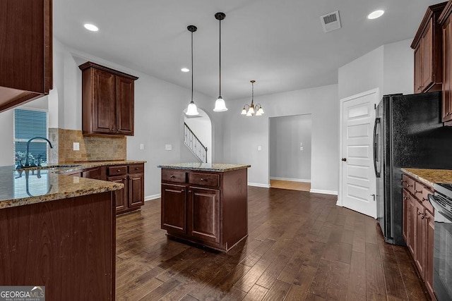 4238 Sir Dixon Dr, Fairburn, GA 30213 - kitchen with a sink, dark wood-style flooring, a chandelier, tasteful backsplash, and light stone counters