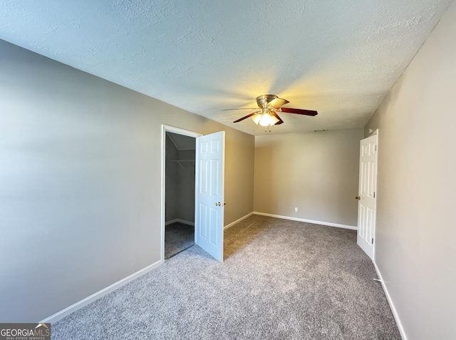3292 Shady Valley Ct, Loganville, GA 30052 - unfurnished bedroom with carpet, a textured ceiling, ceiling fan, a walk in closet, and a closet