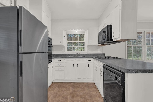 2261 Star Mist Dr SW, Atlanta, GA 30311 - kitchen featuring black appliances, dark countertops, a sink, white cabinetry, and a peninsula