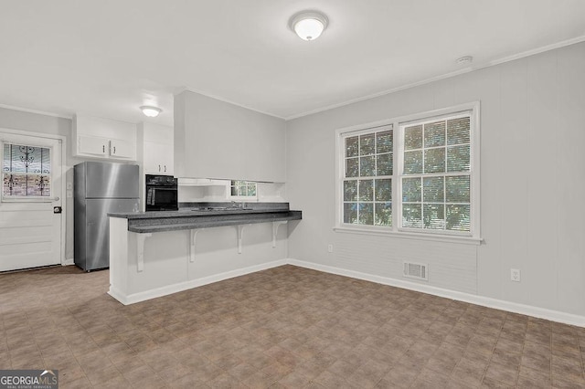 2261 Star Mist Dr SW, Atlanta, GA 30311 - kitchen with freestanding refrigerator, oven, dark countertops, healthy amount of natural light, and crown molding