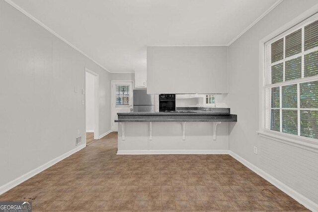 2261 Star Mist Dr SW, Atlanta, GA 30311 - kitchen with ornamental molding, refrigerator, dark countertops, black oven, and baseboards
