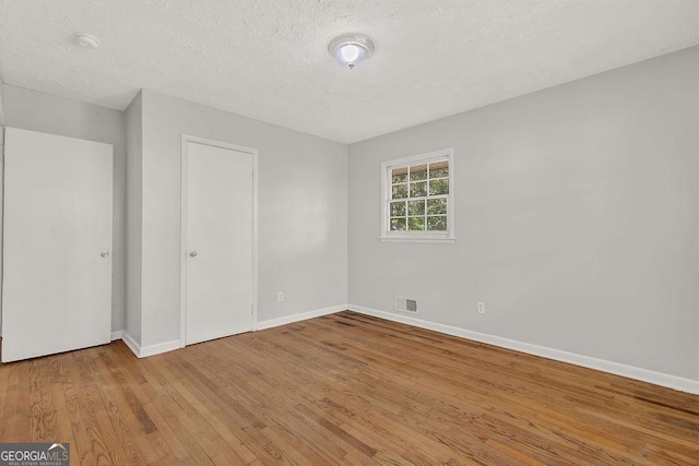 2261 Star Mist Dr SW, Atlanta, GA 30311 - unfurnished bedroom featuring baseboards, wood finished floors, and a textured ceiling