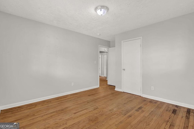 2261 Star Mist Dr SW, Atlanta, GA 30311 - unfurnished bedroom with wood finished floors, a textured ceiling, and baseboards