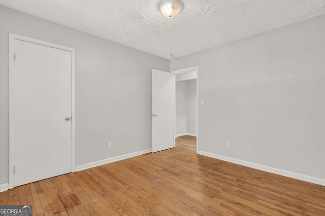 2261 Star Mist Dr SW, Atlanta, GA 30311 - unfurnished room with light wood-style floors, baseboards, and a textured ceiling
