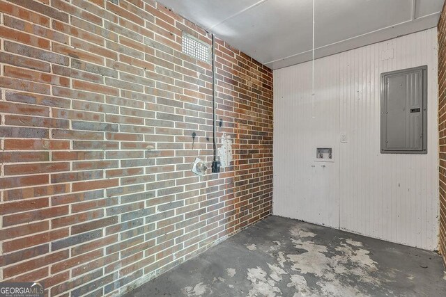 2261 Star Mist Dr SW, Atlanta, GA 30311 - spare room featuring electric panel, unfinished concrete flooring, and brick wall